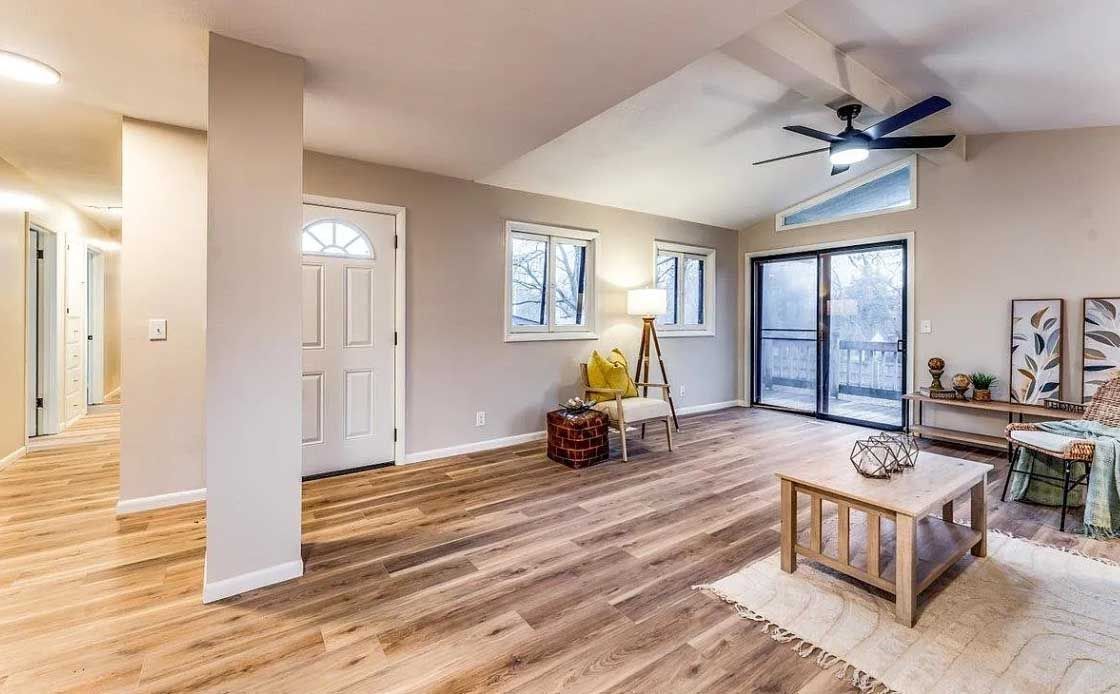 A living room with hardwood floors and a ceiling fan.