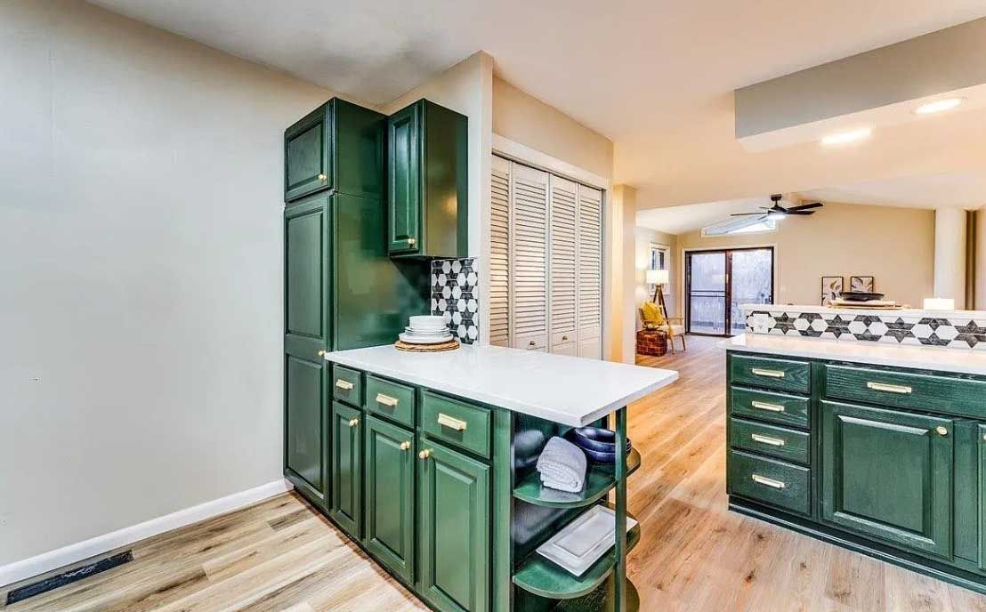 A kitchen with green cabinets and a white counter top.
