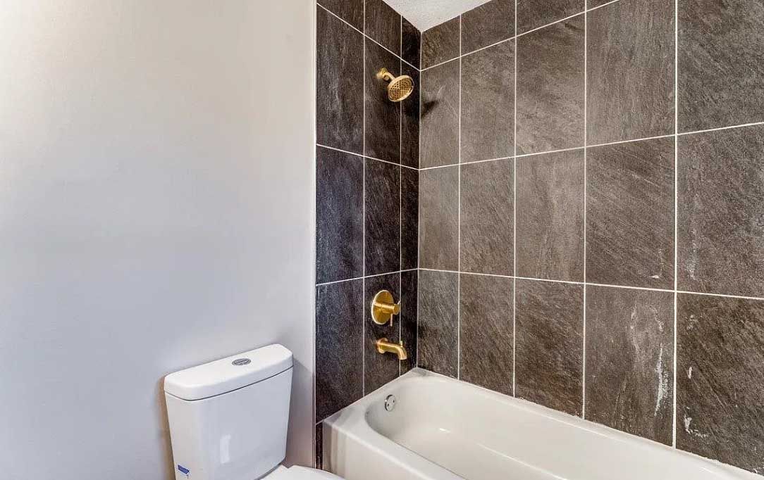 A bathroom with a toilet , bathtub and shower.