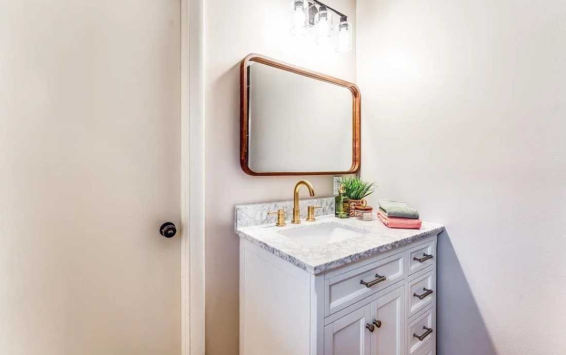 A bathroom with a sink , mirror and faucet.