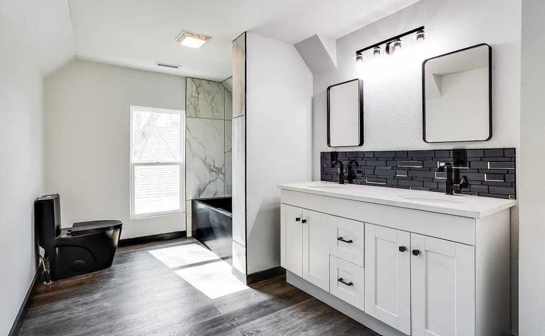 A bathroom with a toilet , sink , mirror and tub.