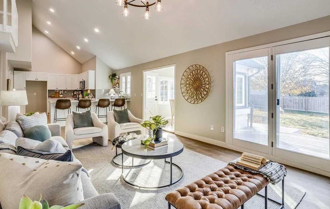 A living room with a couch , chairs , coffee table and ottoman.