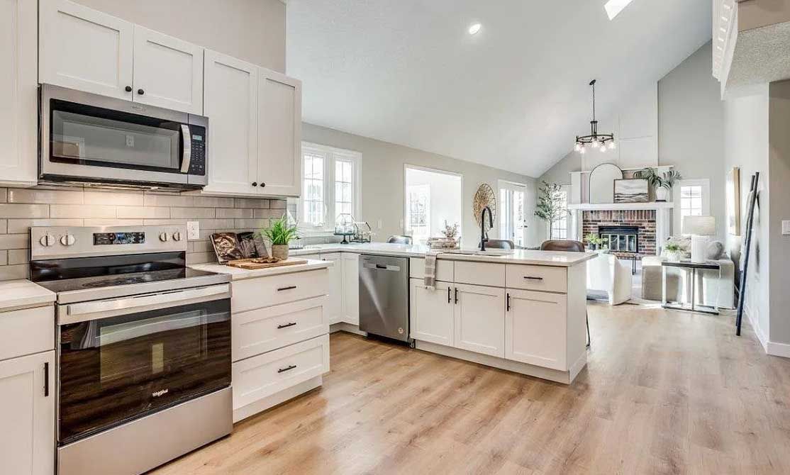 A kitchen with stainless steel appliances and white cabinets.