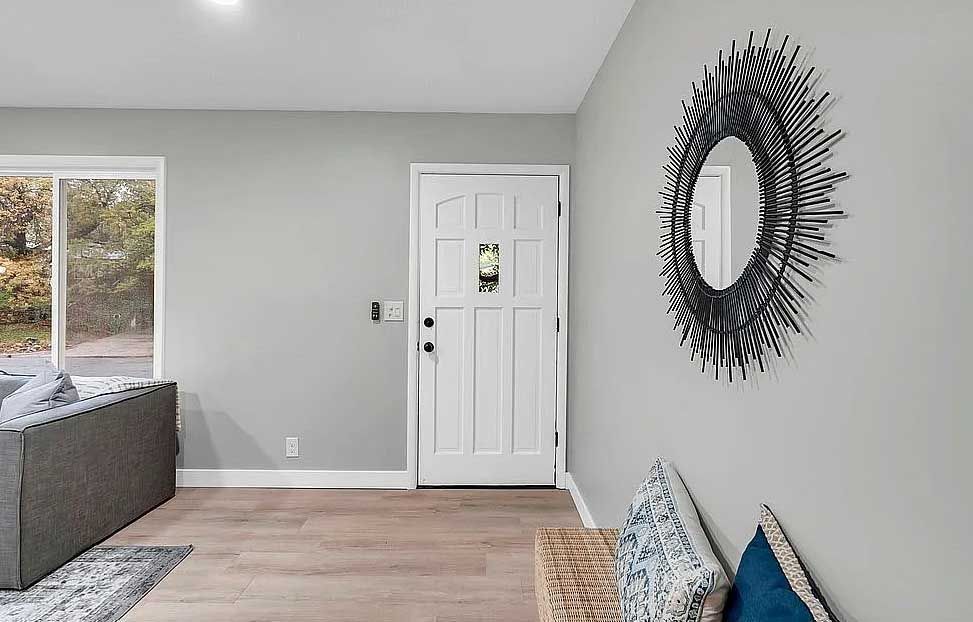 A living room with a couch and a mirror on the wall.