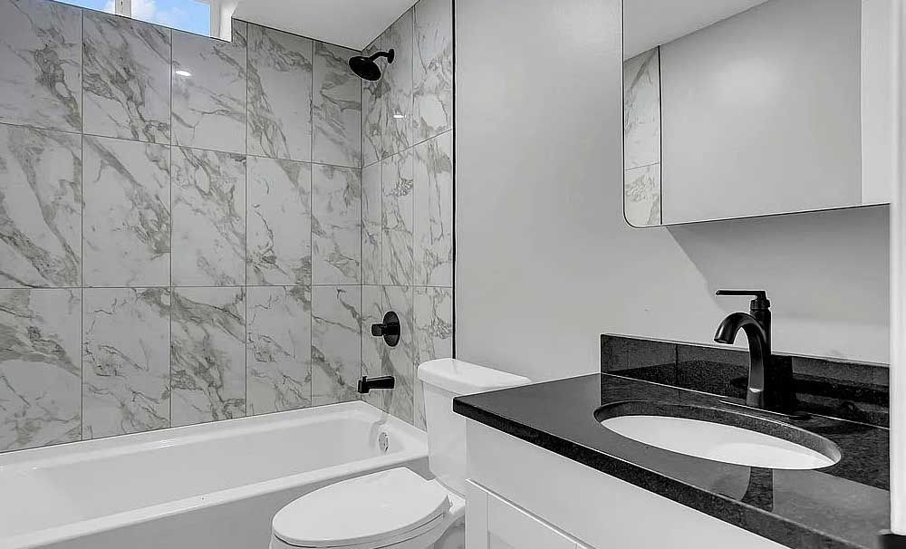 A bathroom with a toilet , sink , bathtub and shower.