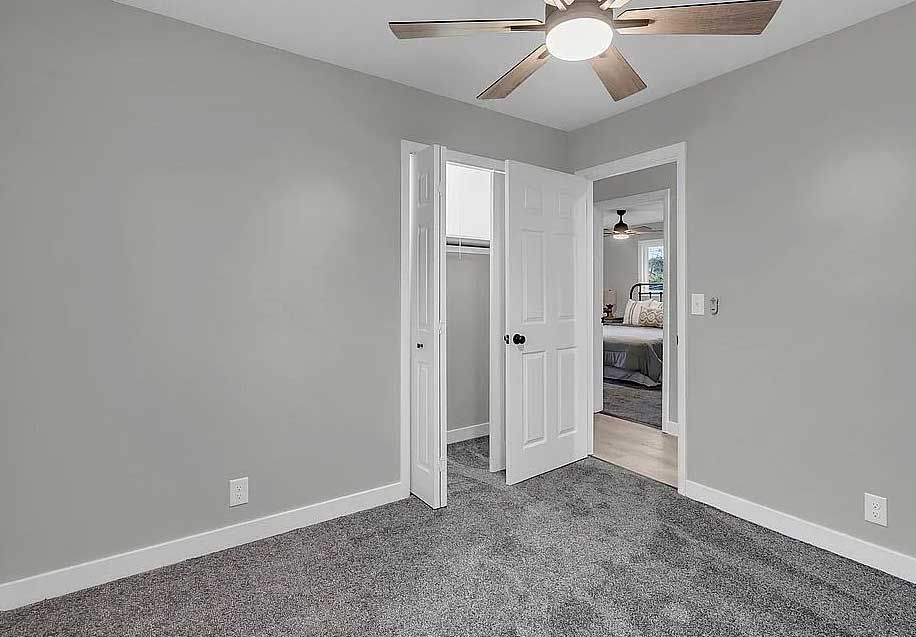 There is a ceiling fan in the corner of the room.