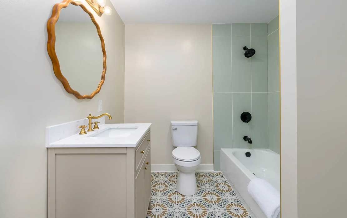 A bathroom with a toilet , sink , mirror and bathtub.