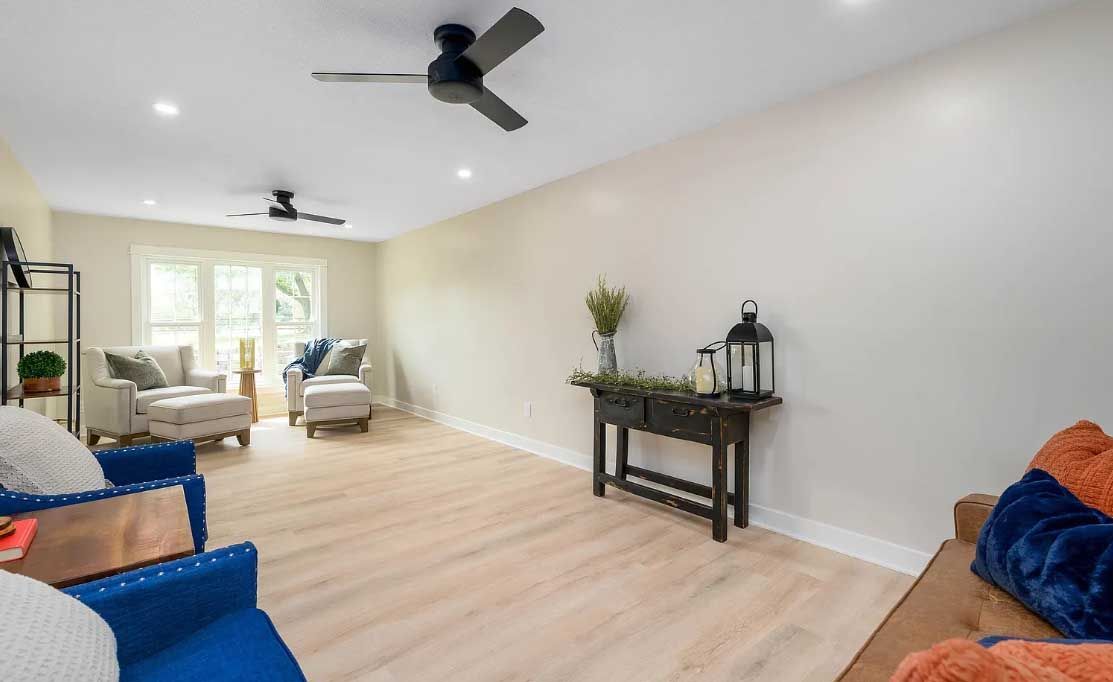A living room filled with furniture and a ceiling fan.