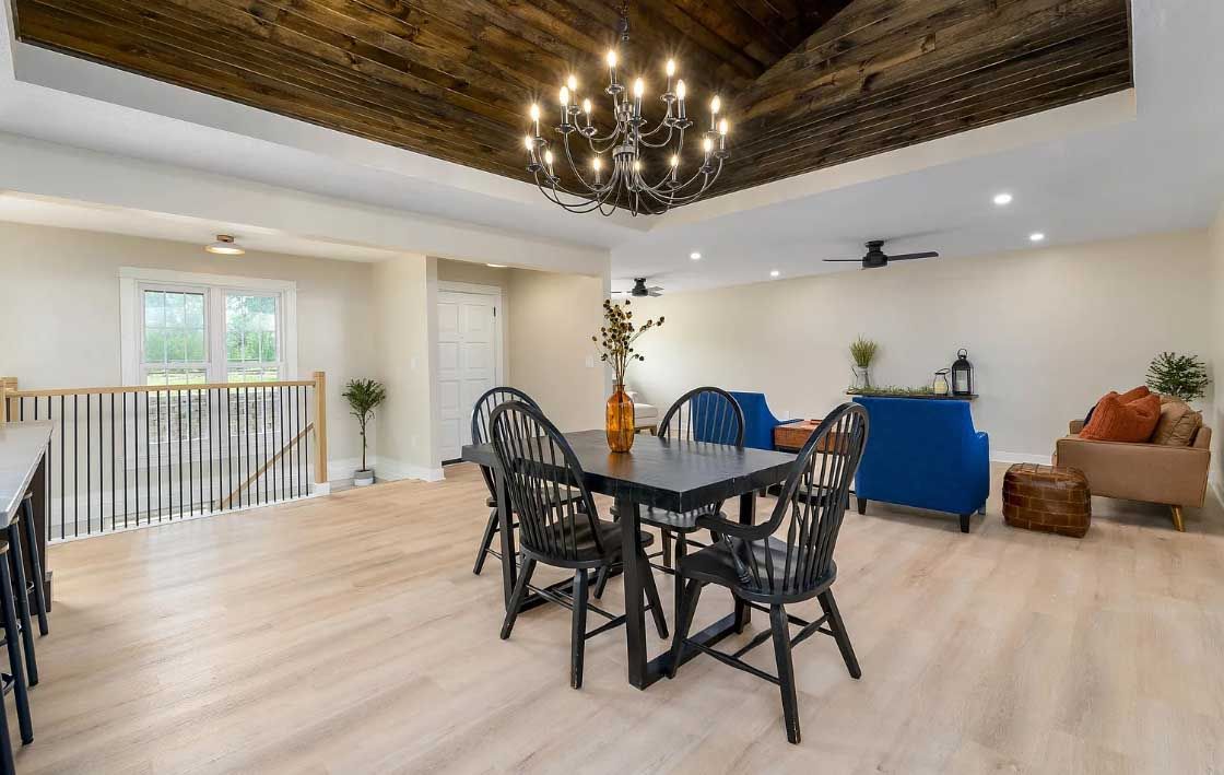 A living room with a dining table and chairs and a chandelier.