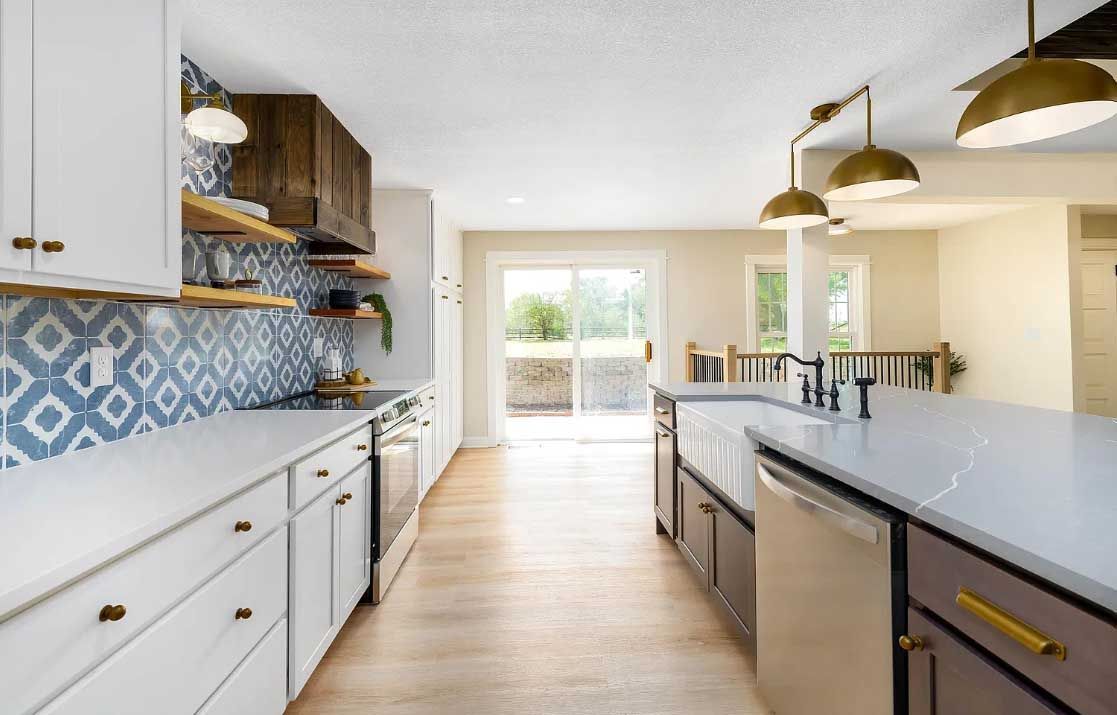 A kitchen with white cabinets , stainless steel appliances , and a large island.