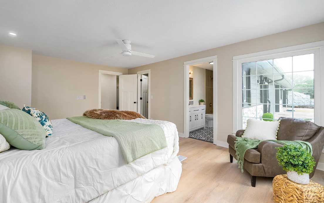 A bedroom with a bed , chair , and ceiling fan.