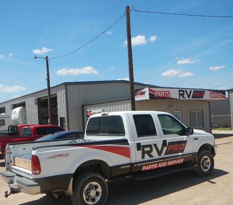 A rv pro truck is parked in front of a building