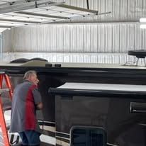 A man is working on a trailer in a garage.