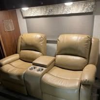 A pair of tan leather recliner chairs in a living room.