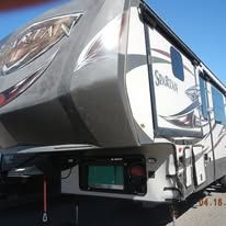 A rv is parked in a parking lot on a sunny day.