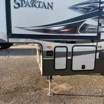A spartan trailer is parked on the side of the road.