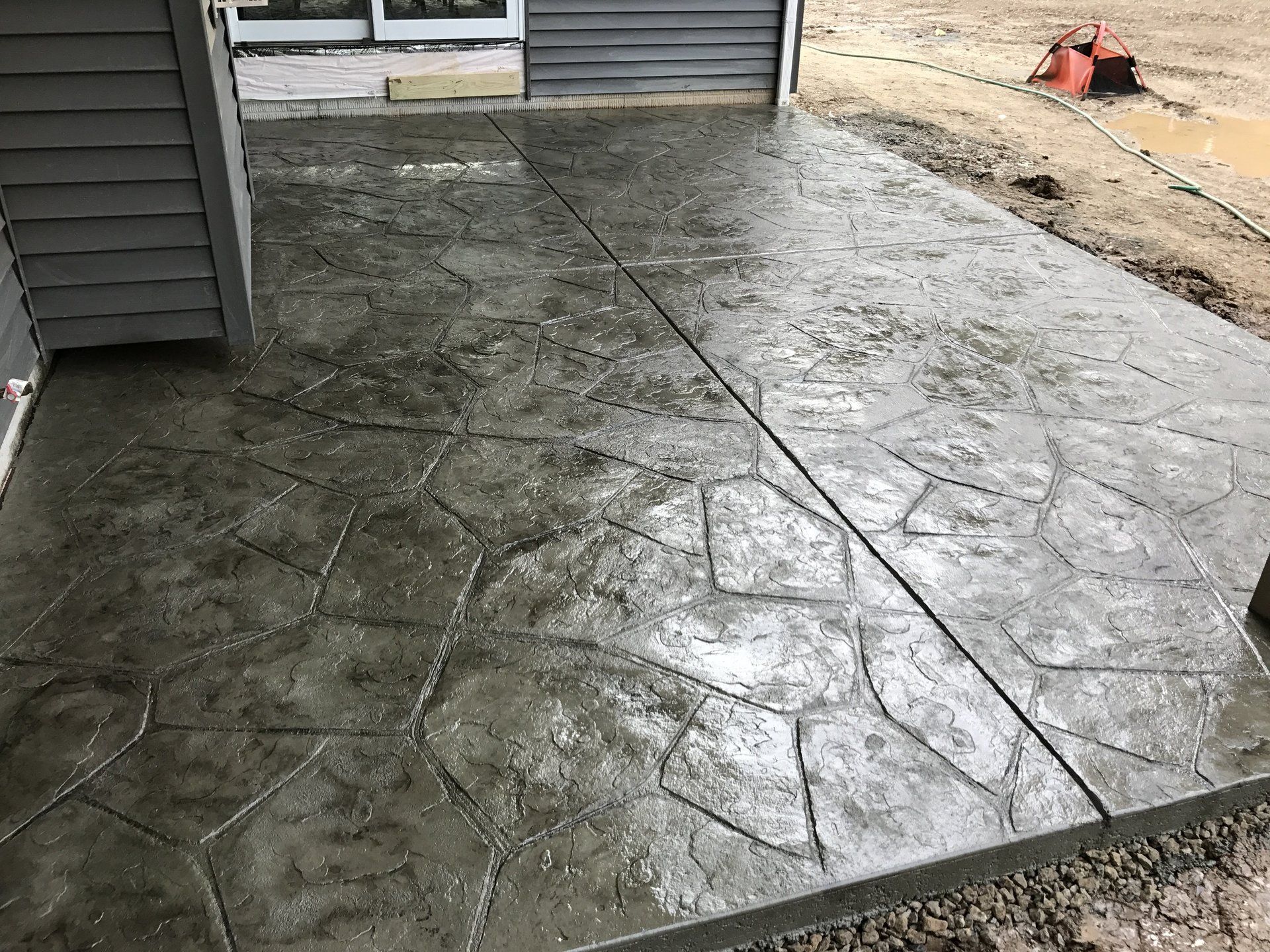 A concrete patio is being built in front of a house.