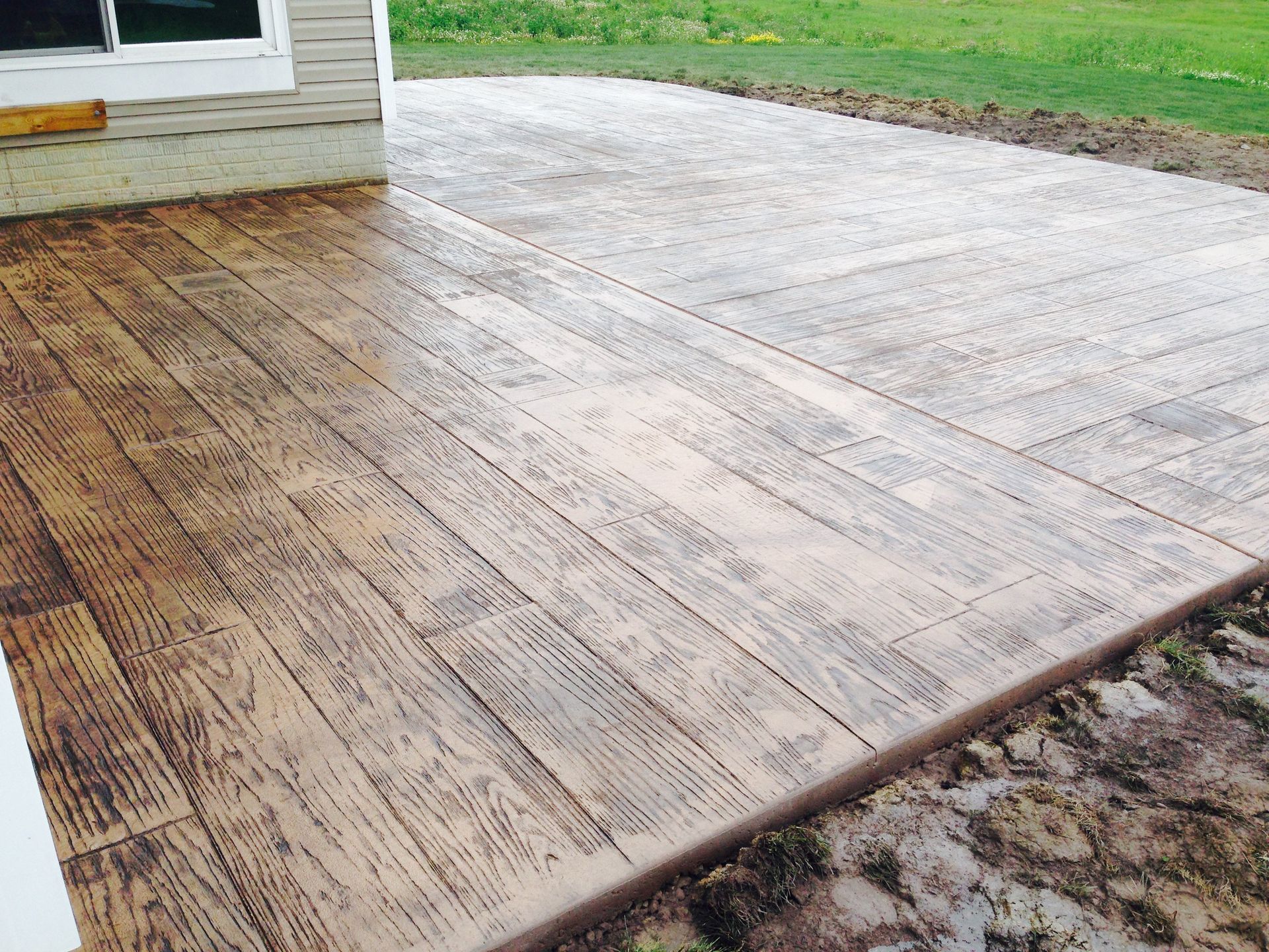 A concrete patio with a wood grain pattern on it
