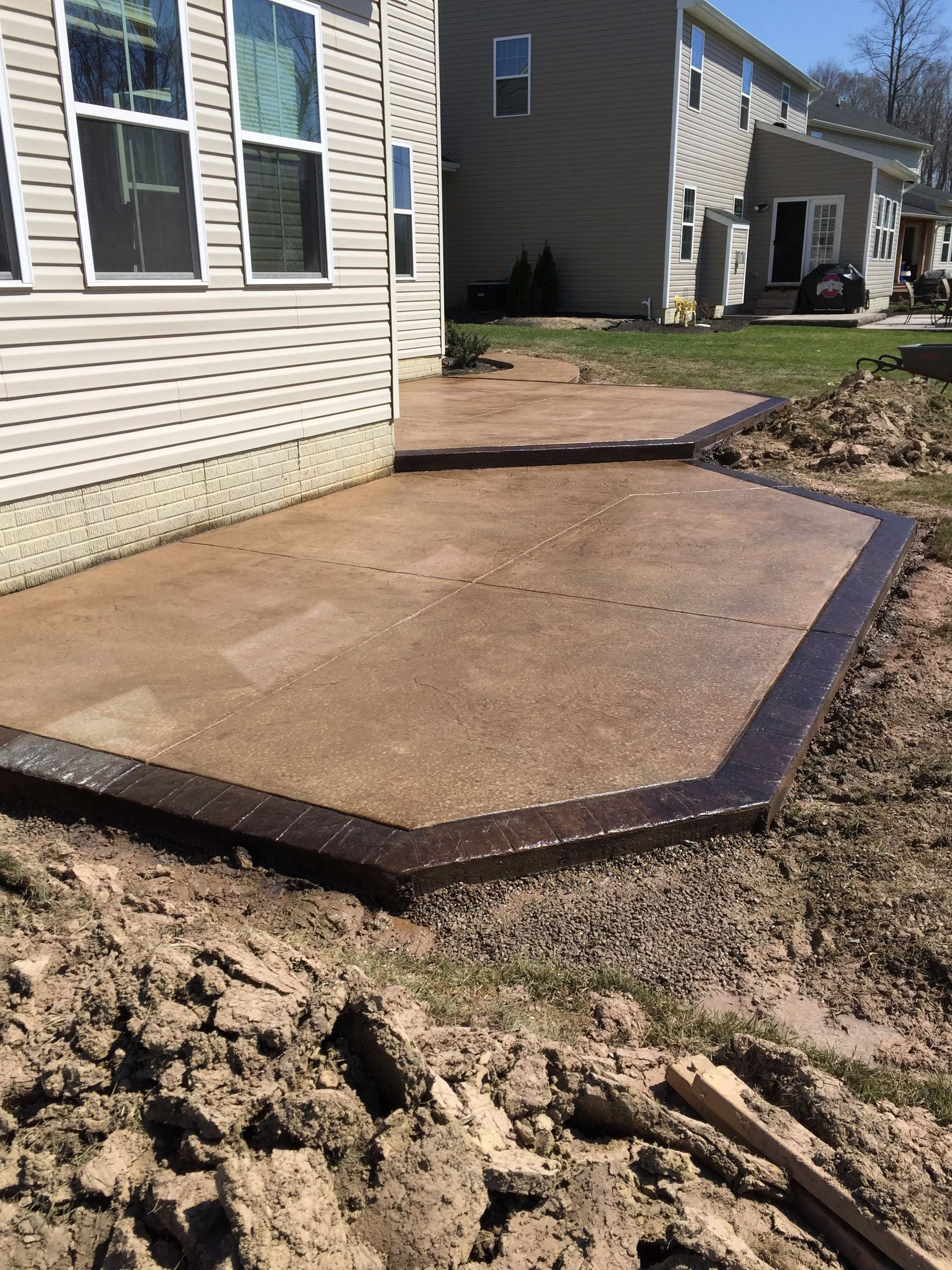 A concrete patio is being built in front of a house