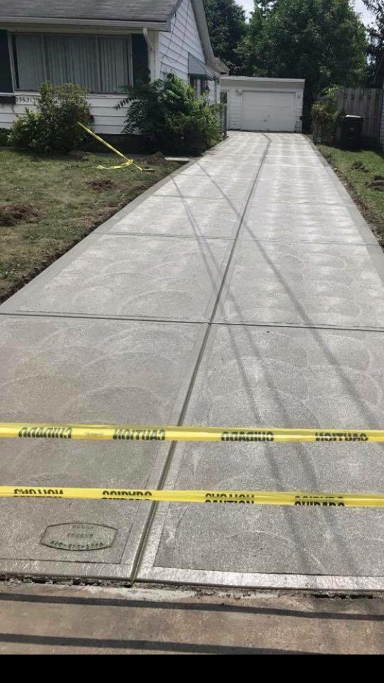 A concrete driveway is being built in front of a house.