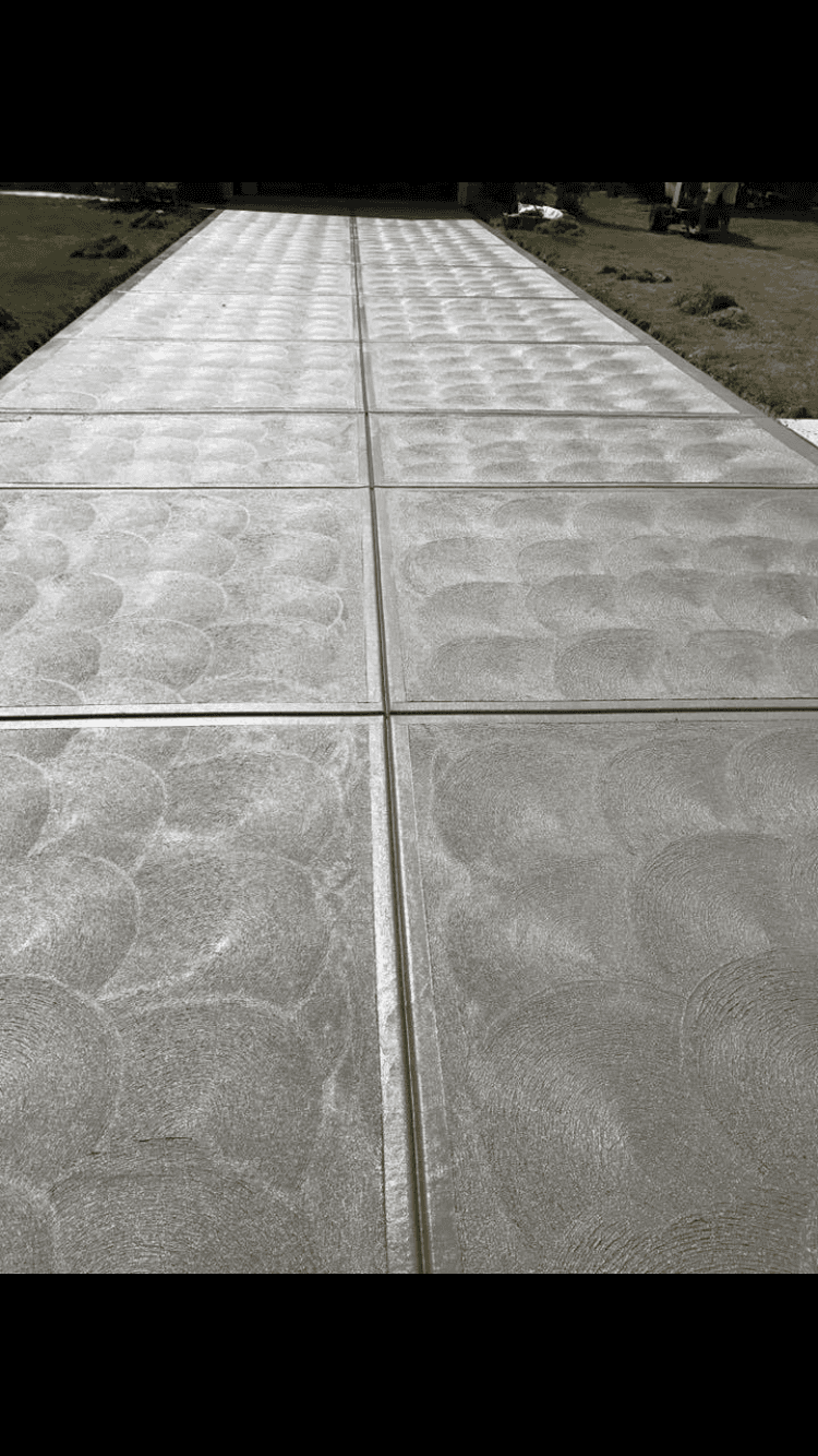 A black and white photo of a concrete driveway.