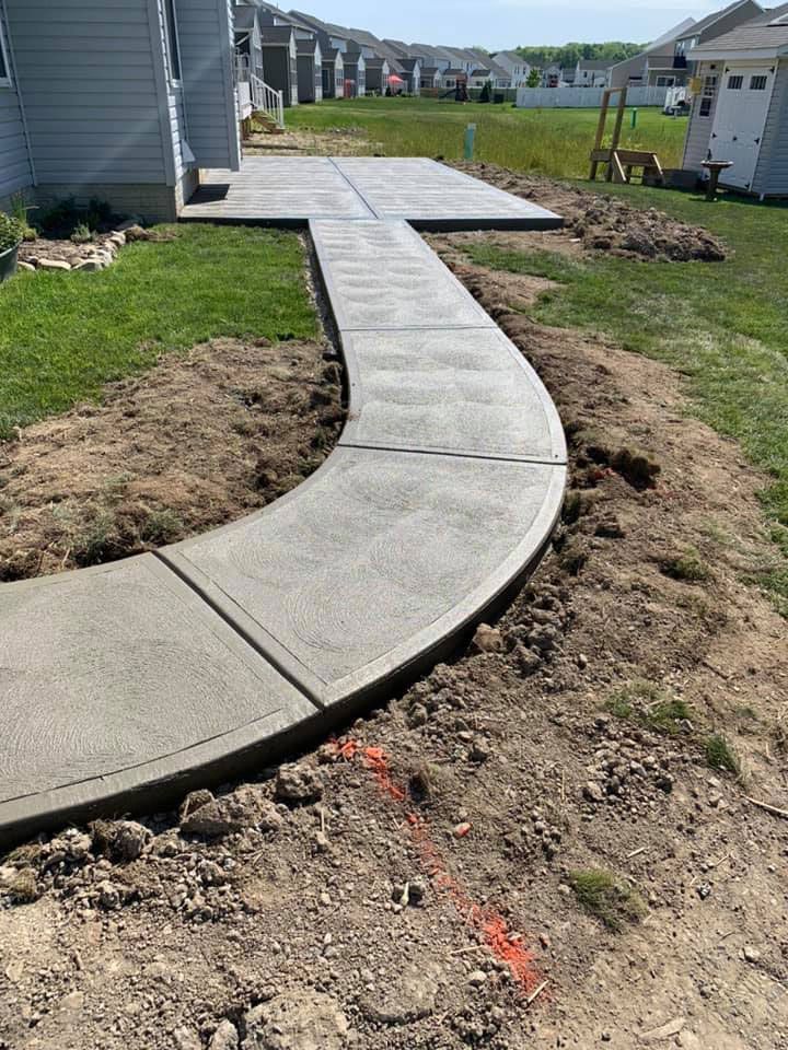 A concrete walkway is being built in front of a house.