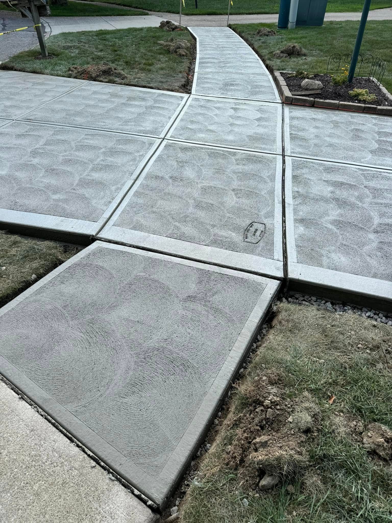 A concrete walkway is being built in a yard.