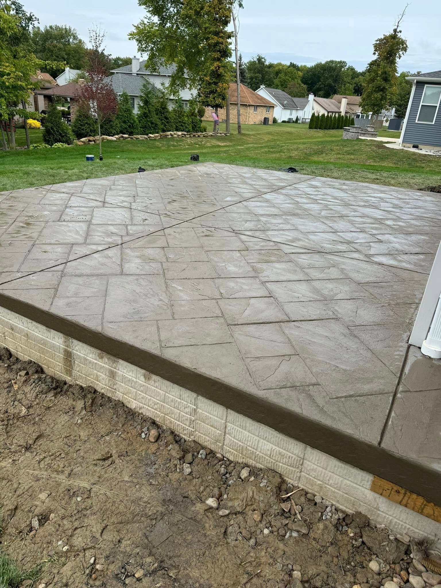 A concrete driveway is being built in a residential area.