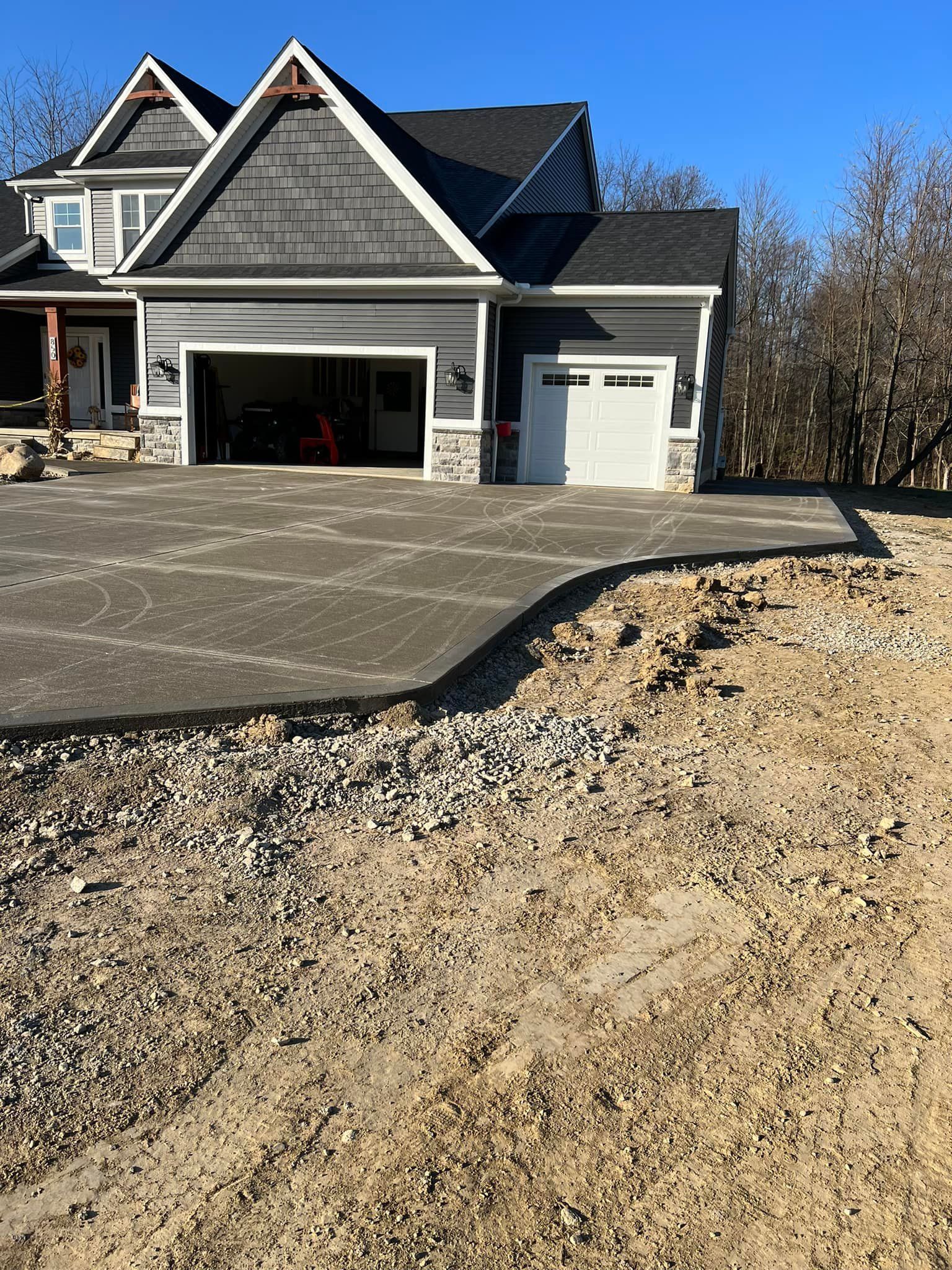 A large house with a concrete driveway in front of it.