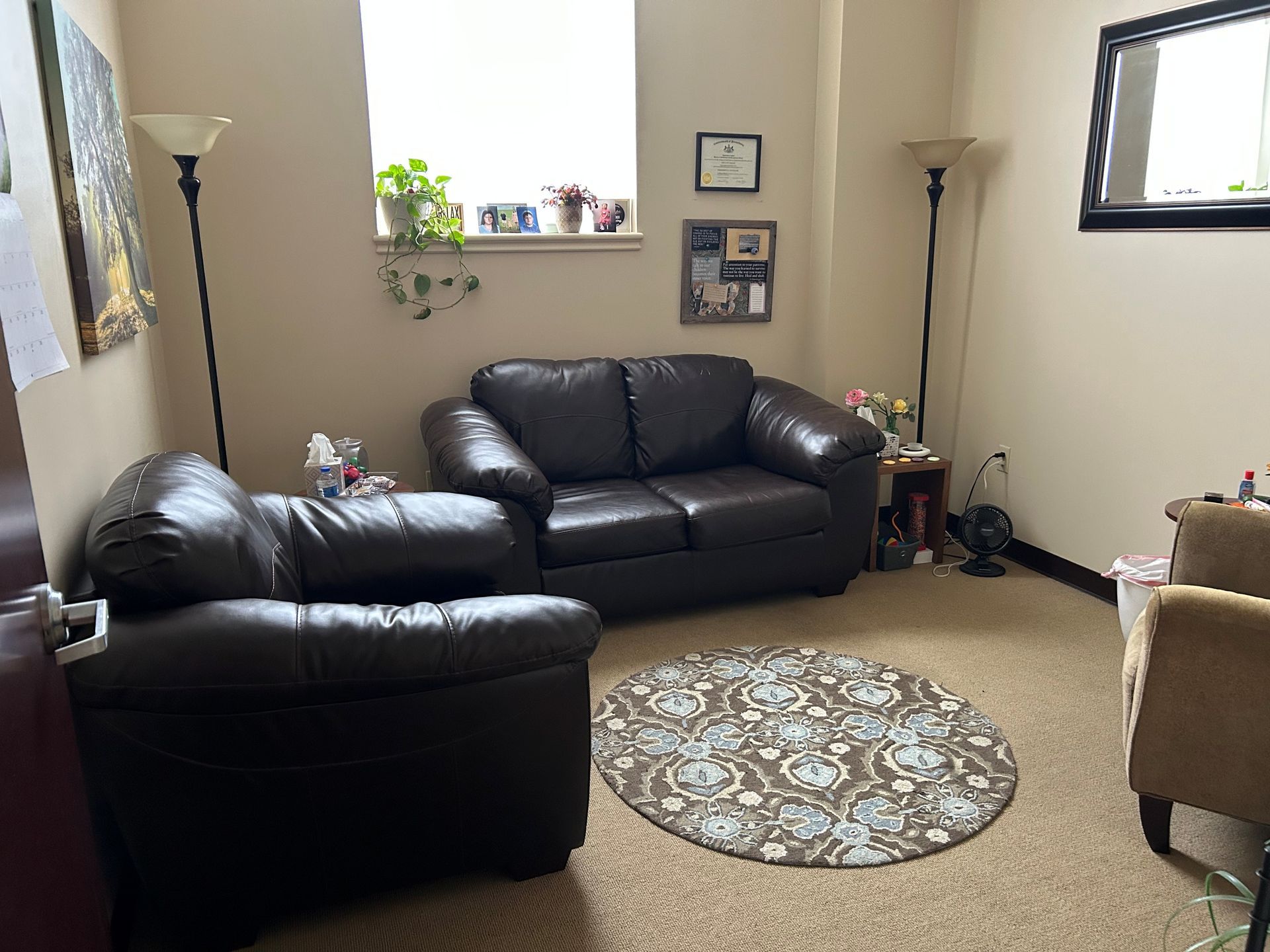 A living room with a couch, chairs, and a rug.