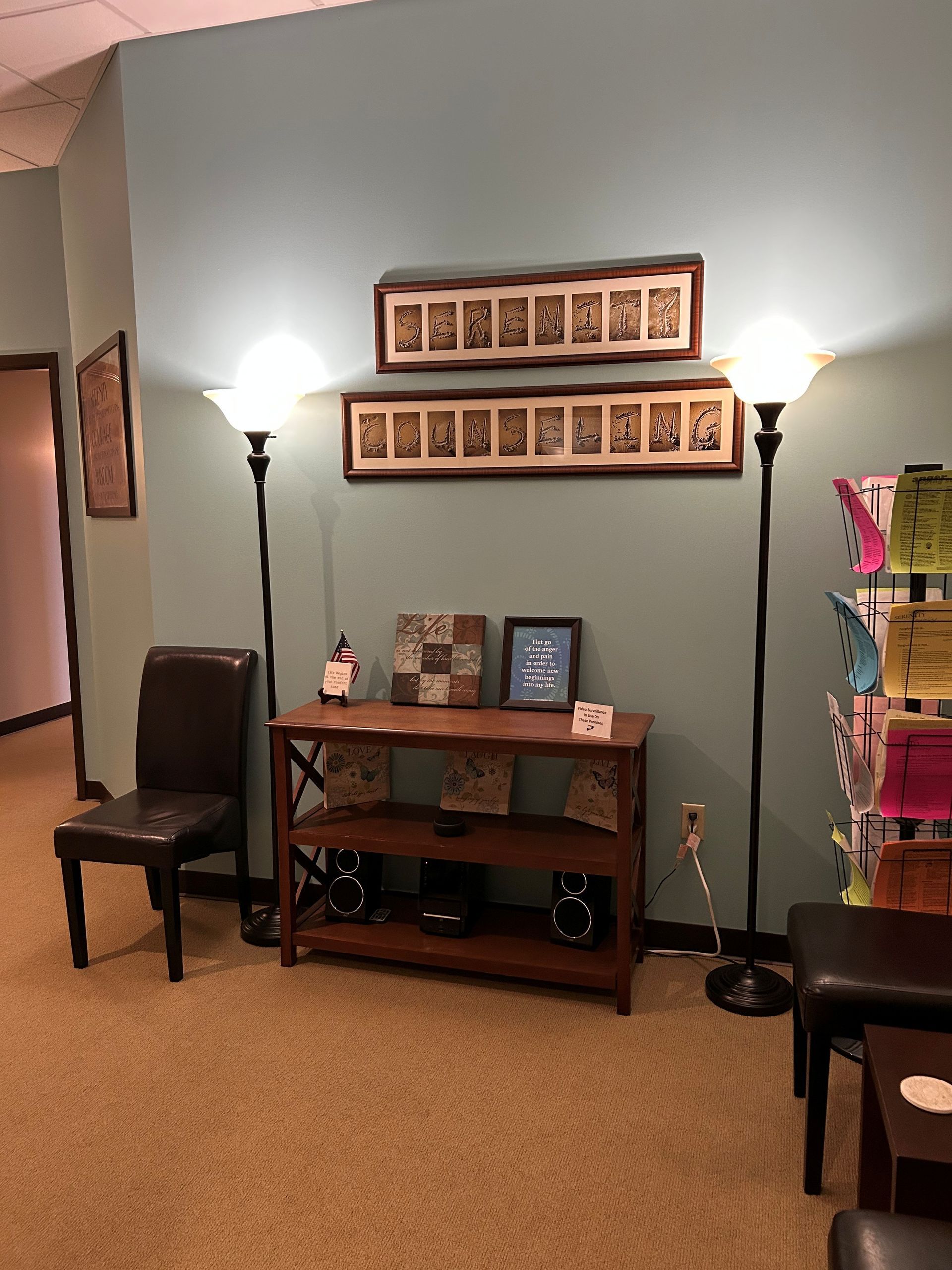 A waiting room with a table and chairs and pictures on the wall.