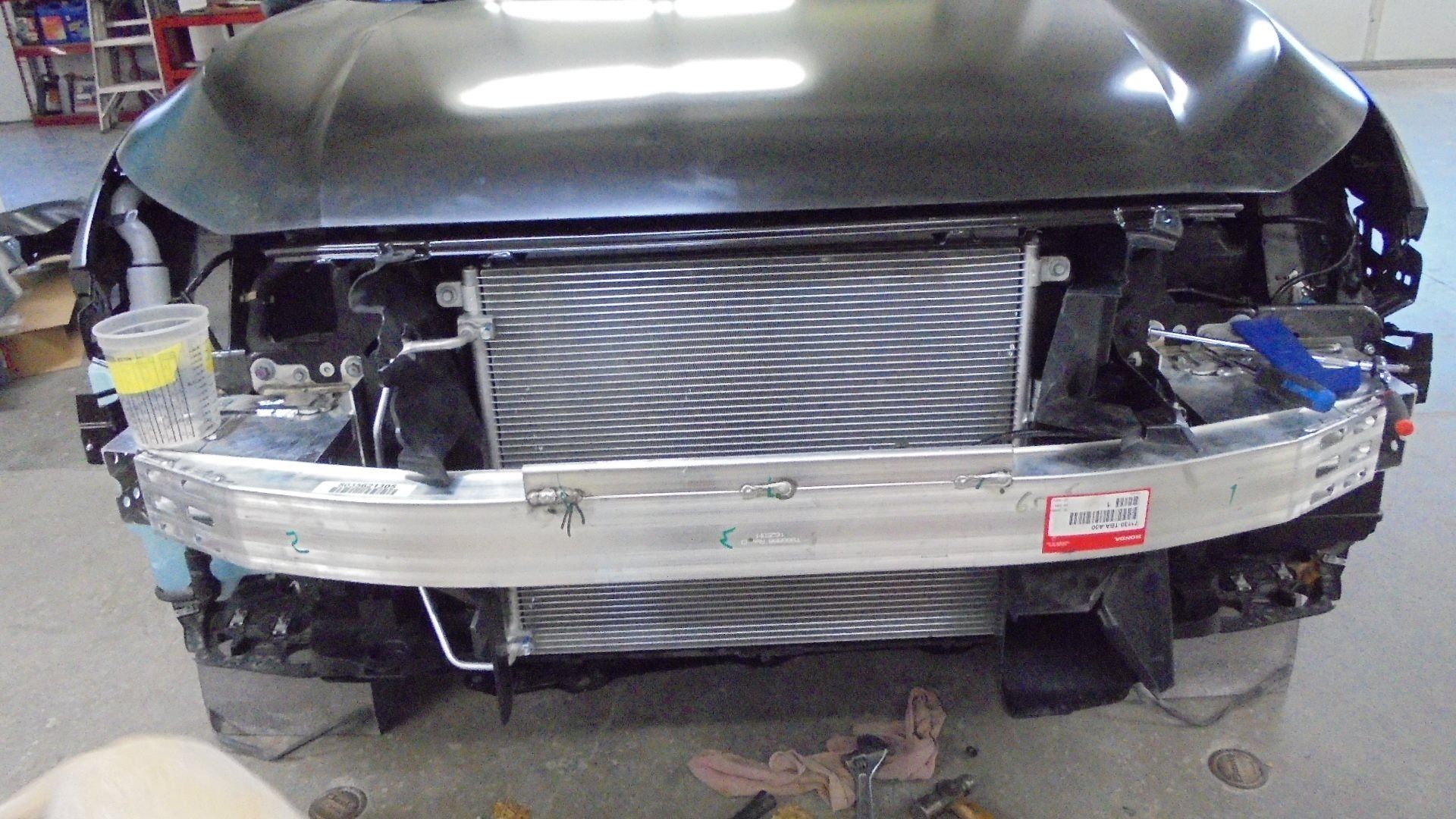 Front of a black car with the bumper and other parts removed, revealing the radiator.