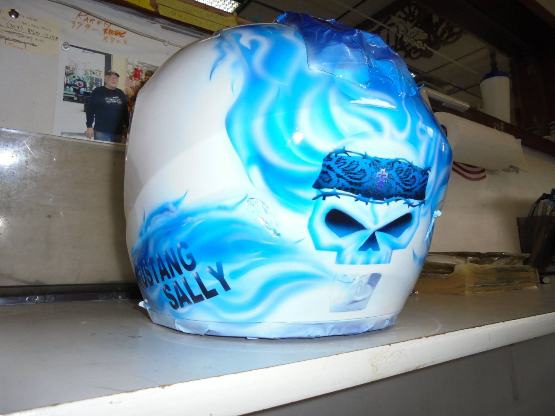 White helmet with blue flame and skull design,