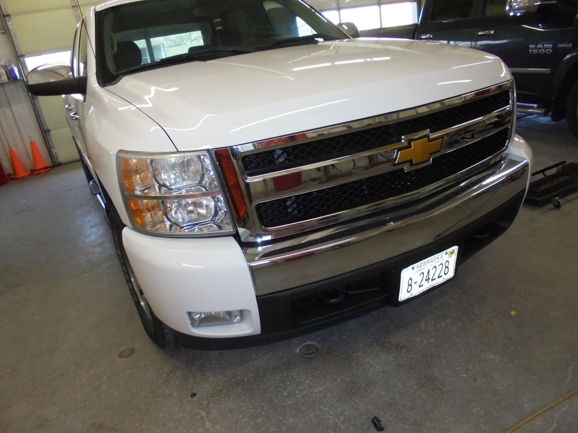 White Chevrolet pickup truck, front view, in a garage.