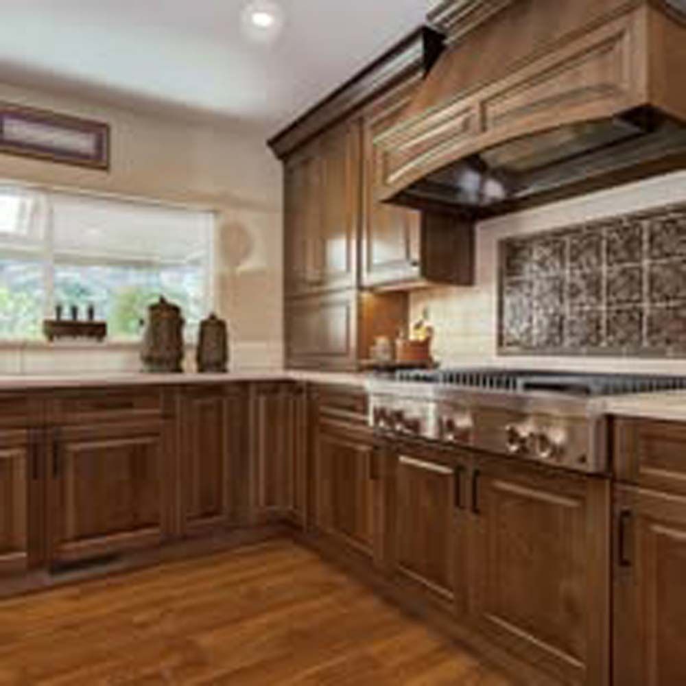 Wooden kitchen with cabinets, stove, and a range hood.  Light streams in through a window.