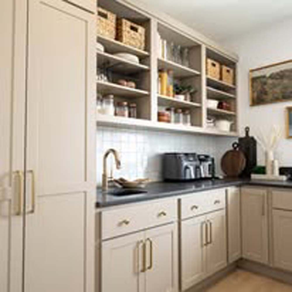 Beige kitchen with open shelves, cabinets, and a sink.