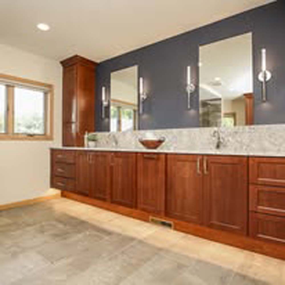 Modern kitchen with island, white cabinetry, and turquoise island with two bar stools.