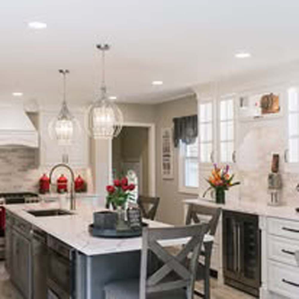 Bathroom with dark wood cabinets, blue-gray wall, dual mirrors, and light gray flooring.