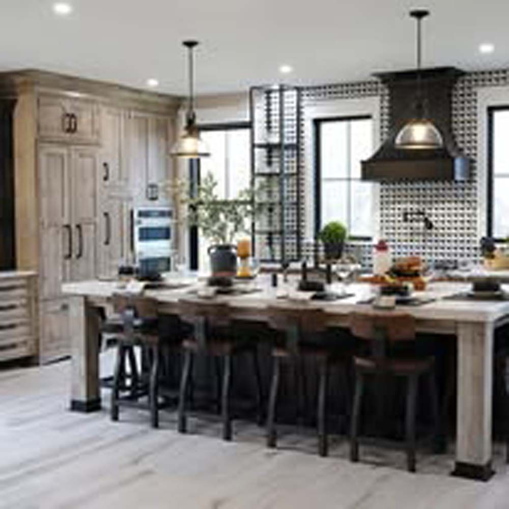 A large kitchen island with seating. The kitchen has wood cabinets, dark accents, and a black and white tiled backsplash.