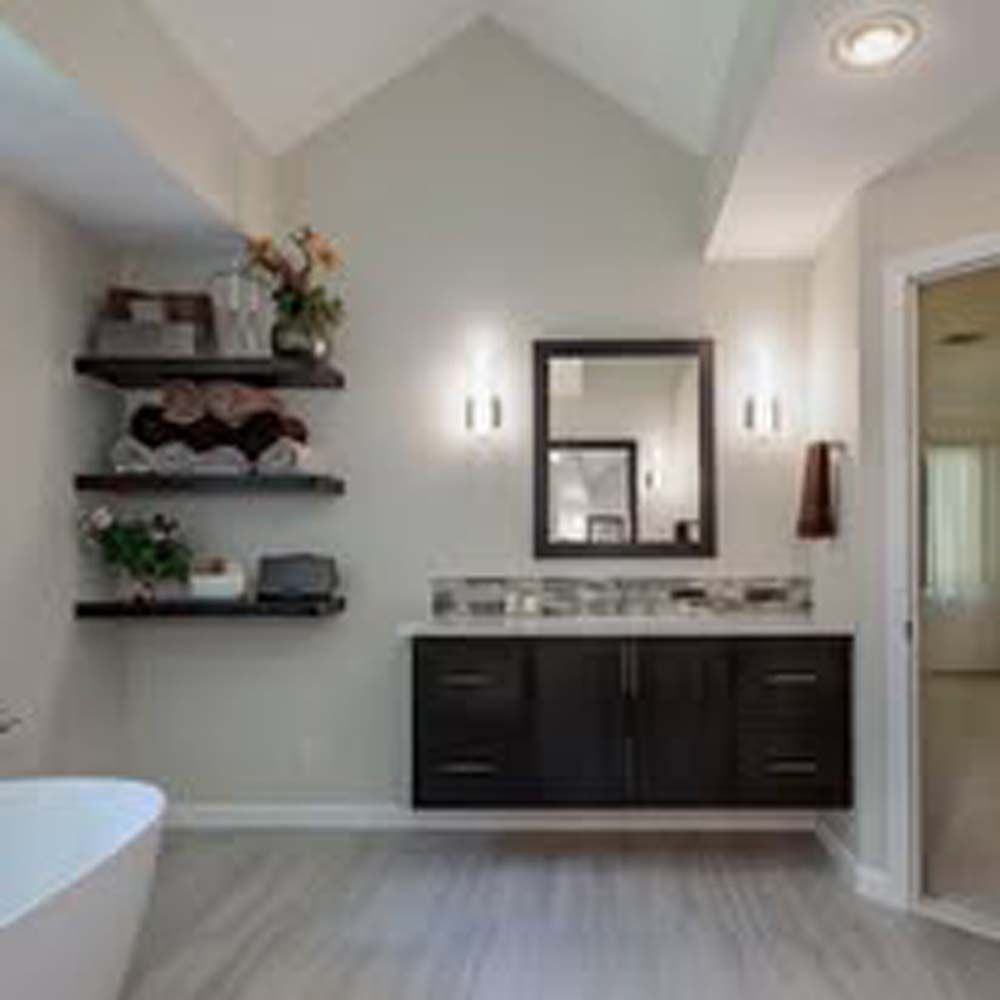 Modern bathroom with dark wood vanity, floating shelves, and a large mirror.
