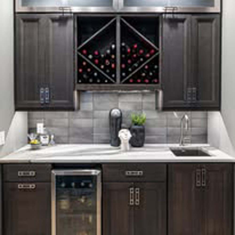 Dark wood home bar with cabinets, a wine rack, sink, and wine fridge.