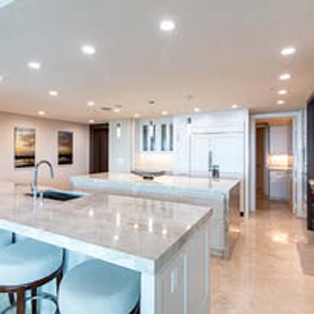 Modern kitchen with island, countertops, and recessed lighting.