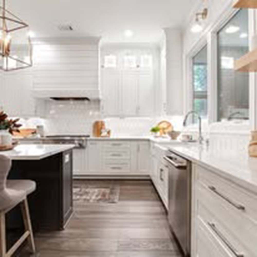 Modern kitchen with white cabinets, island, and wood floors.