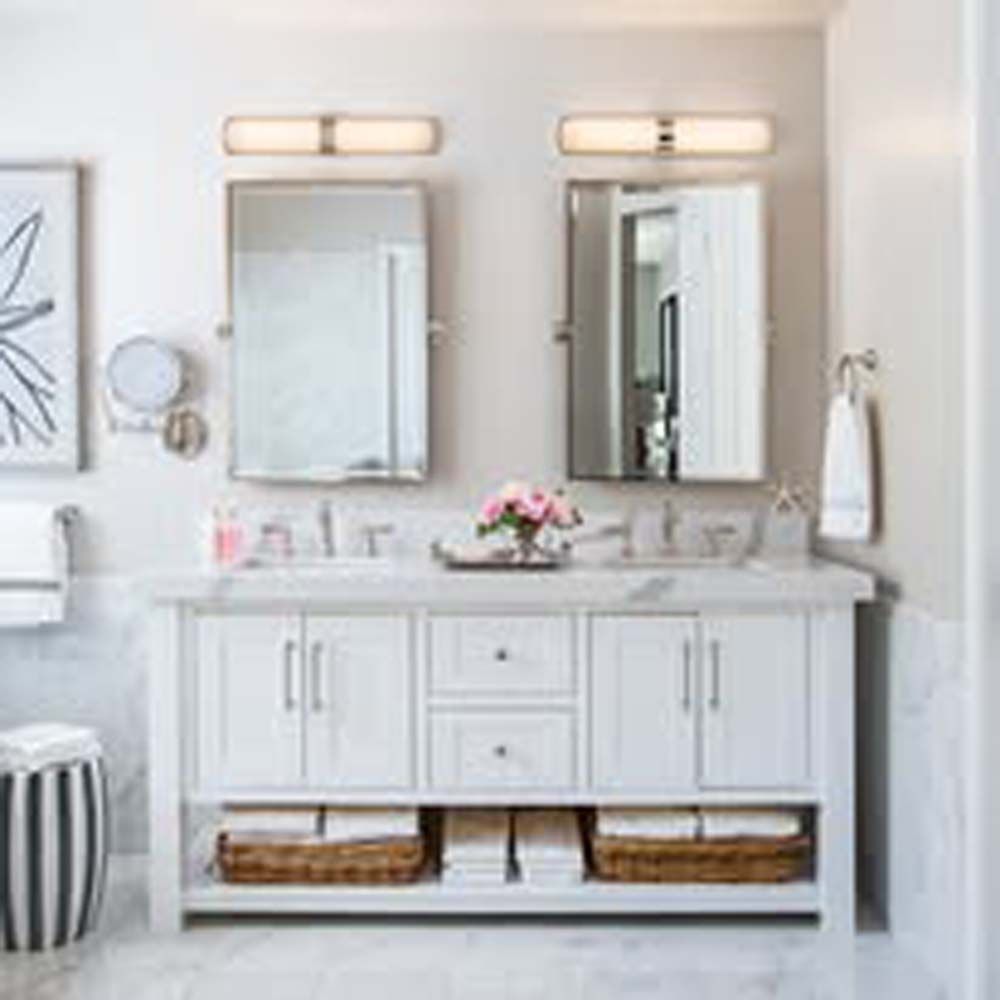 White double vanity with mirrors, lights, and towels in a bathroom.