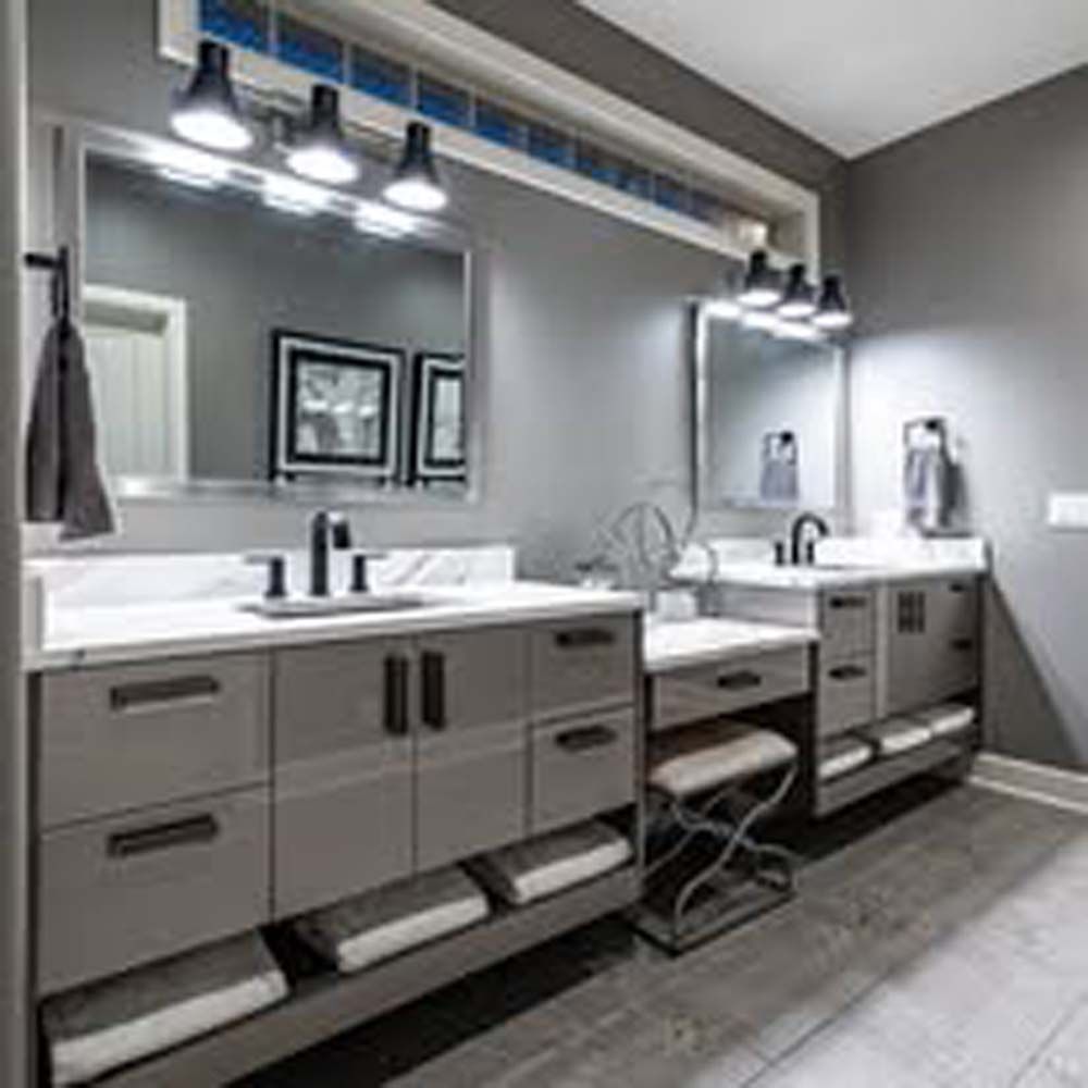 Gray bathroom with double vanity, mirrors, and shelving.