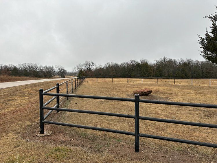 There is a fence in the middle of a field.