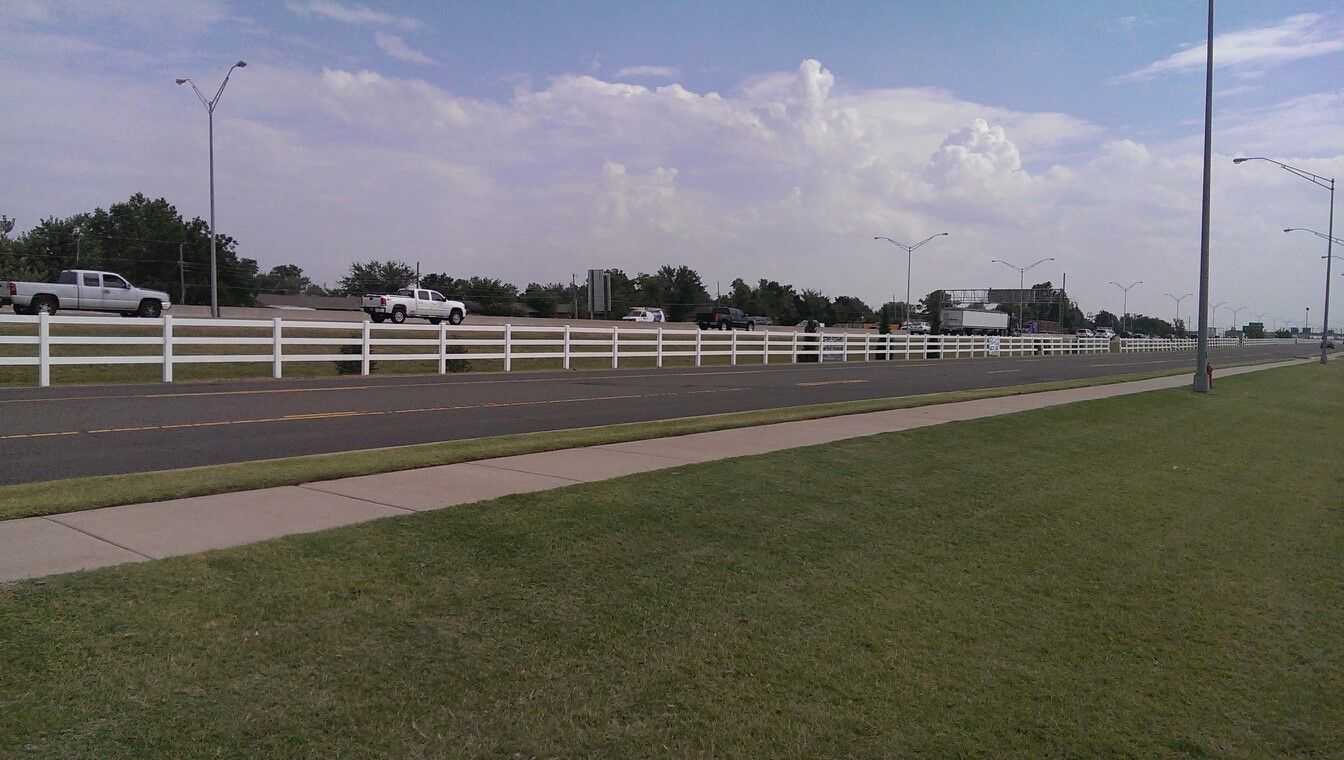 A white fence along the side of a road