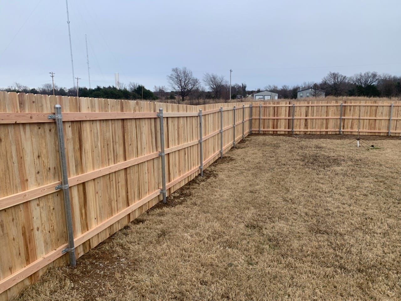 A wooden fence is sitting in the middle of a grassy field