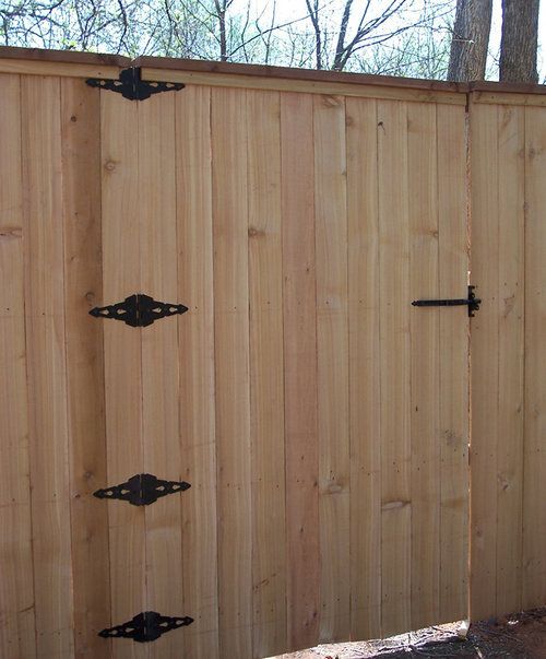A wooden fence with black hinges on it