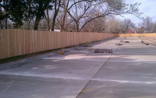 A wooden fence is being built on the side of a road.
